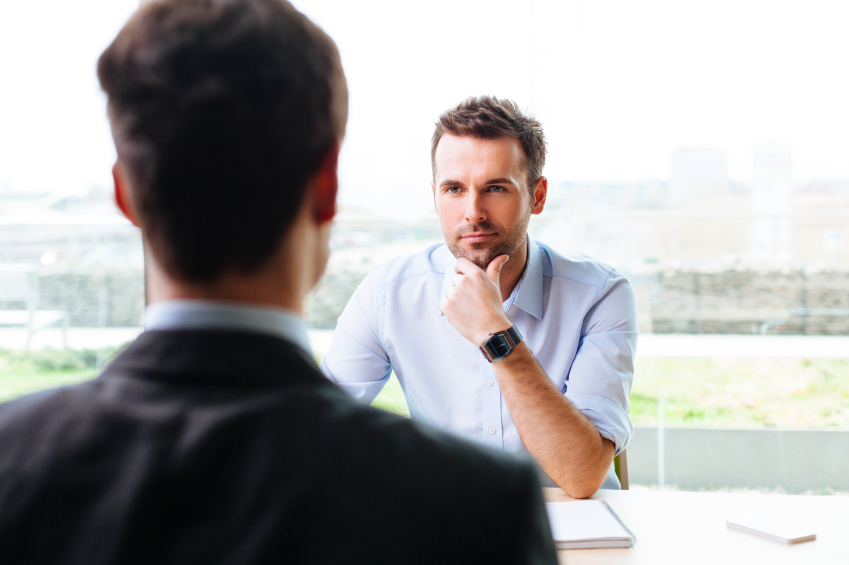 Image of a job interview. Learn about seven interview biases that can sway hiring decisions.