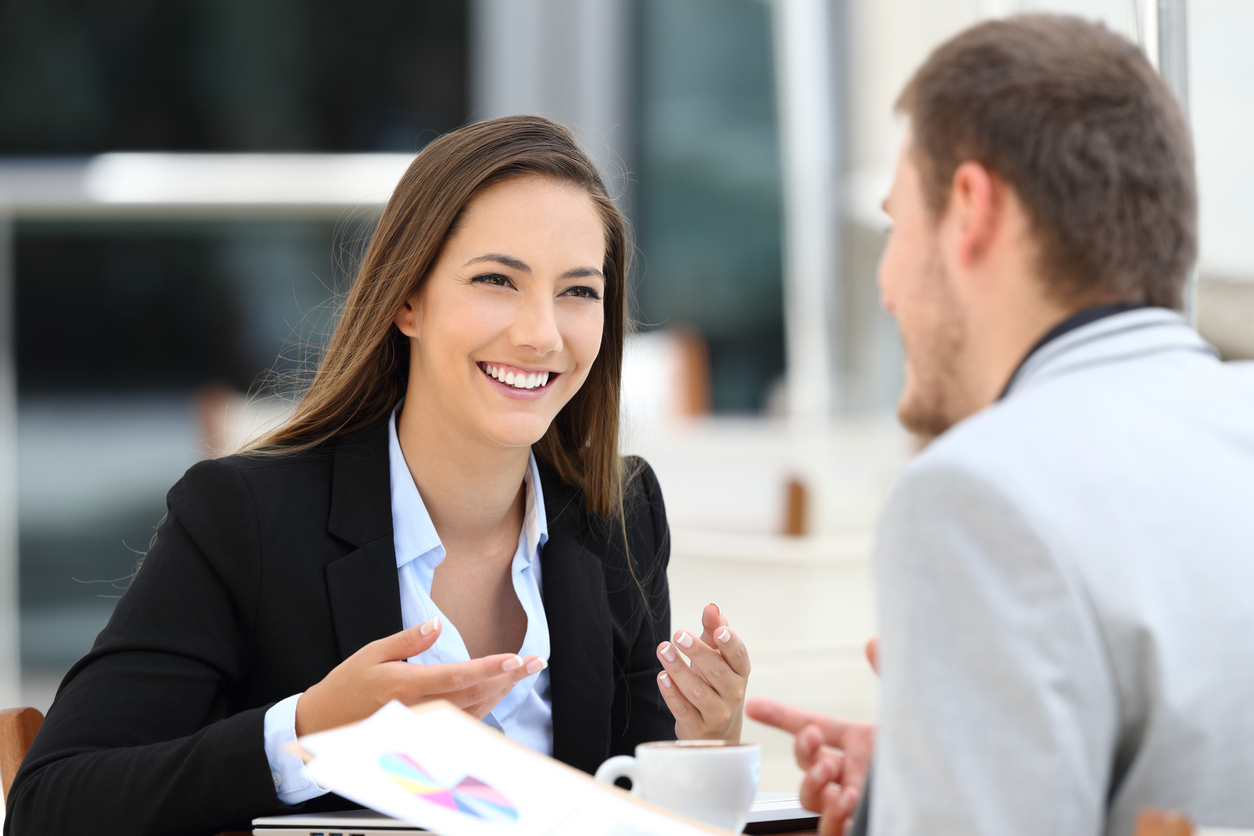 A small business owner going through a performance management review with a happy employee.