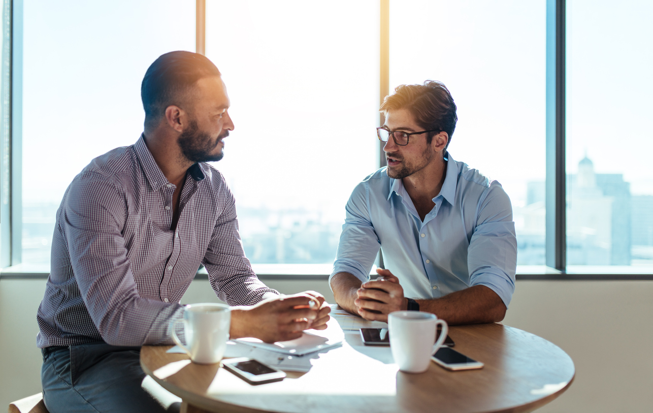 A small business owner and an employee reviewing marijuana policies in the employee handbook.