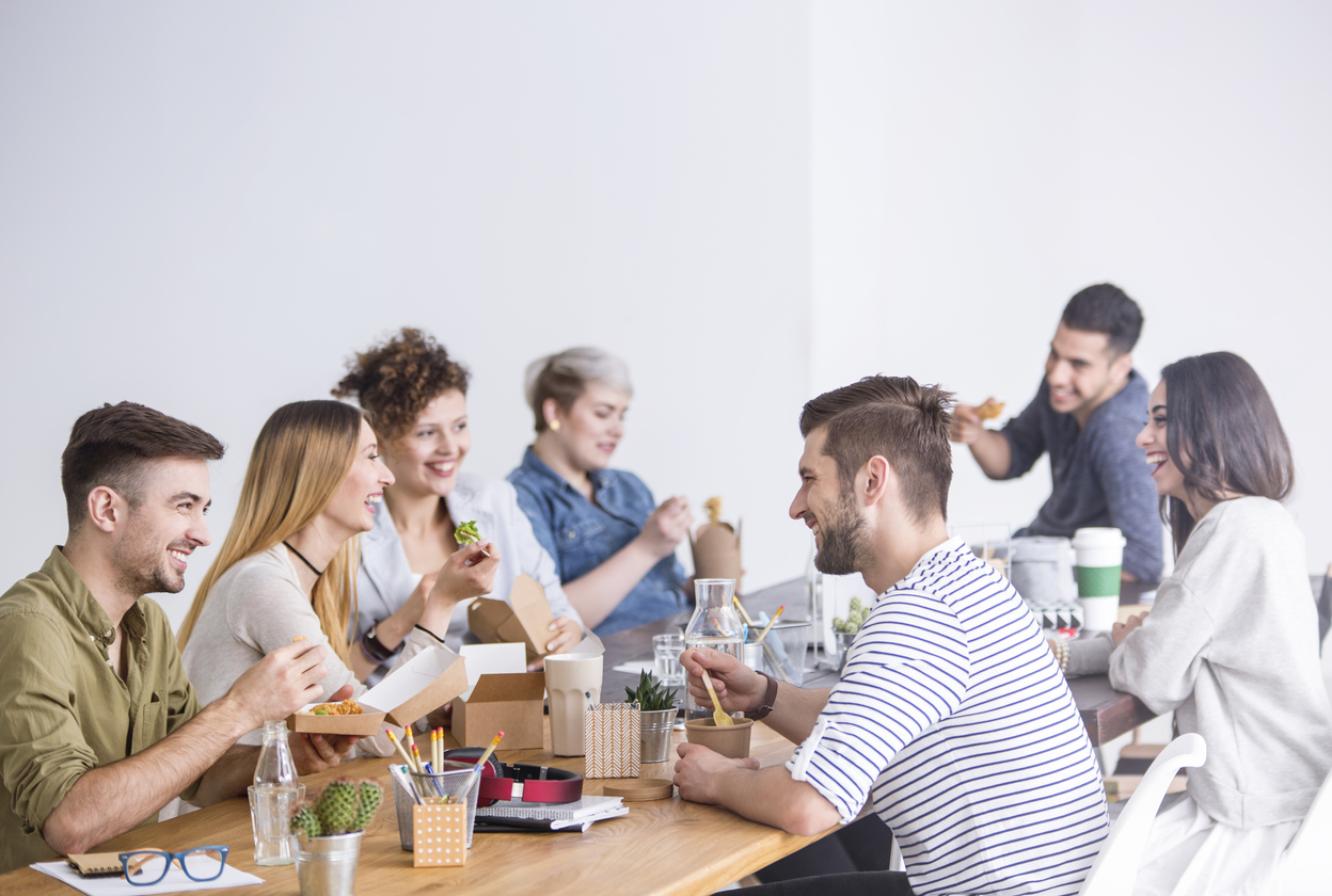 A group of employees eating with one employee's daughter during Take Your Kids to Work Day.