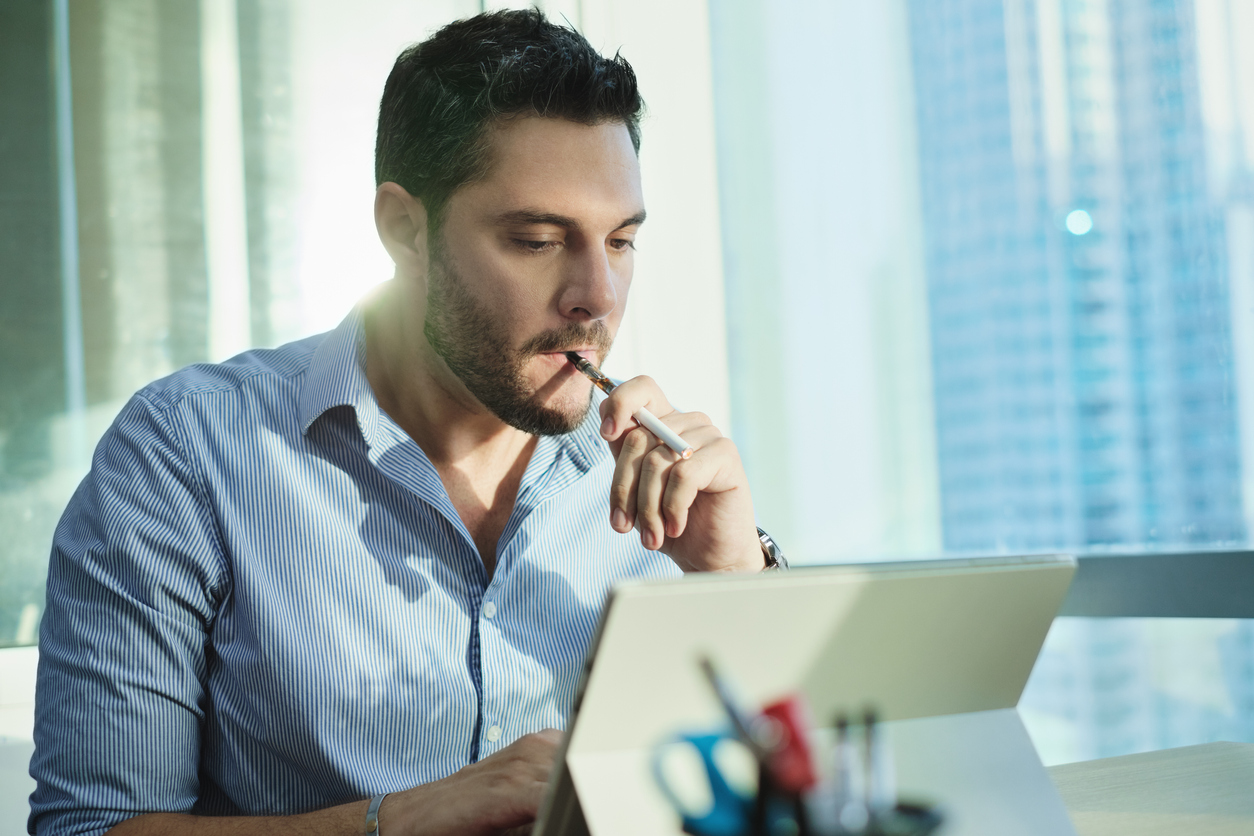 An employee vaping in the office before Florida’s ban on vaping in the workplace.