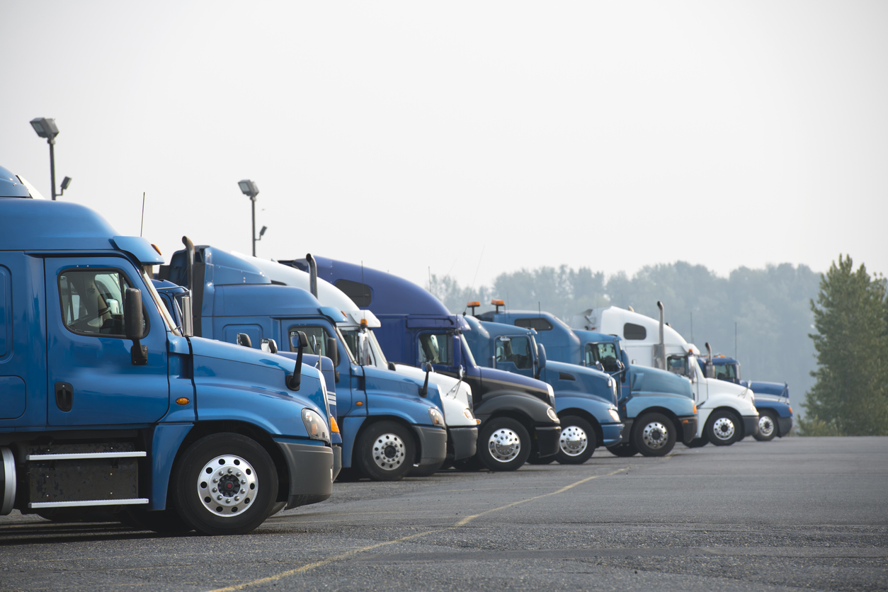 A line of trucks being driven by people hired into the transportation industry.