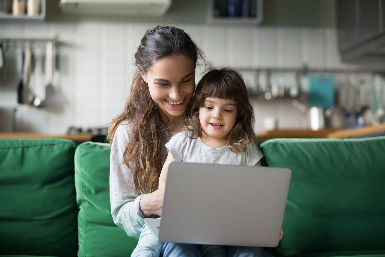 An employee working at home with her daughter thanks to a family-friendly workplace policy.